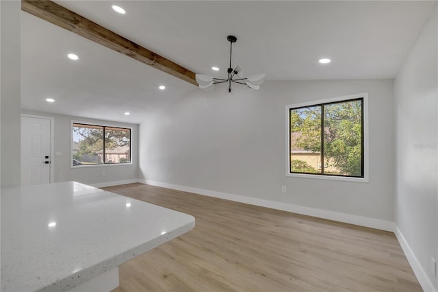 unfurnished living room with lofted ceiling with beams, light hardwood / wood-style floors, and an inviting chandelier