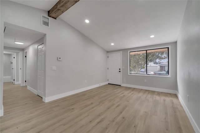 unfurnished room featuring vaulted ceiling with beams and light hardwood / wood-style floors