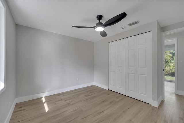 unfurnished bedroom featuring ceiling fan, a closet, and light wood-type flooring