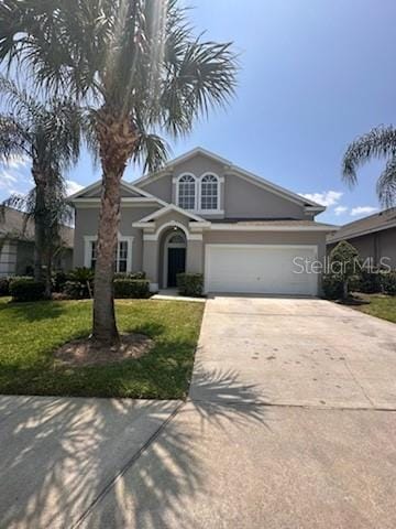 view of front of property with a garage and a front lawn