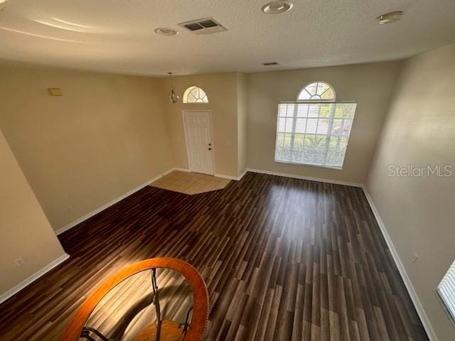 interior space featuring dark hardwood / wood-style floors, a textured ceiling, and an inviting chandelier