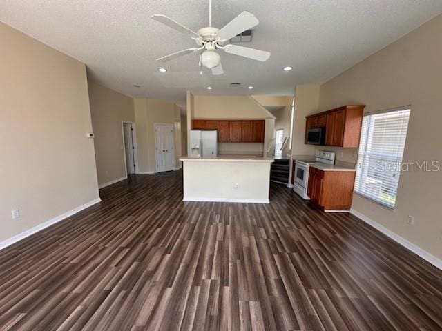 kitchen with ceiling fan, a center island, dark hardwood / wood-style floors, a textured ceiling, and white appliances