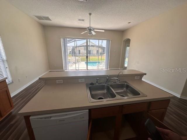 kitchen with dark hardwood / wood-style flooring, white dishwasher, a kitchen island with sink, and sink