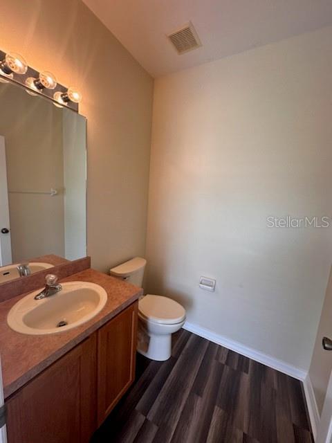 bathroom featuring hardwood / wood-style floors, vanity, and toilet