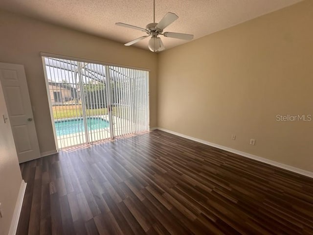 empty room featuring dark hardwood / wood-style floors, ceiling fan, and a textured ceiling