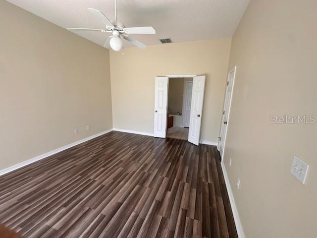 empty room featuring dark hardwood / wood-style floors and ceiling fan