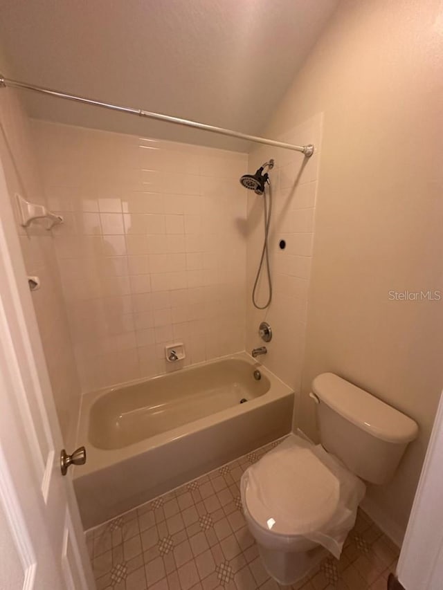 bathroom featuring toilet and tiled shower / bath