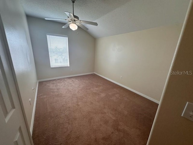 carpeted empty room with a textured ceiling, ceiling fan, and lofted ceiling