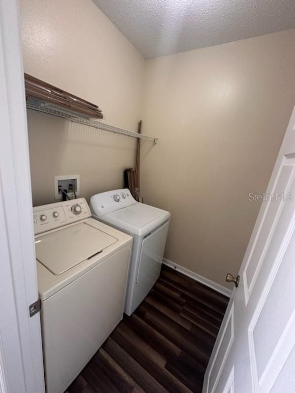 laundry area with washer and dryer, a textured ceiling, and dark wood-type flooring