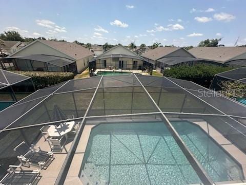 view of swimming pool featuring glass enclosure