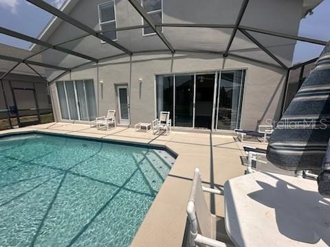 view of pool with a patio area and a lanai