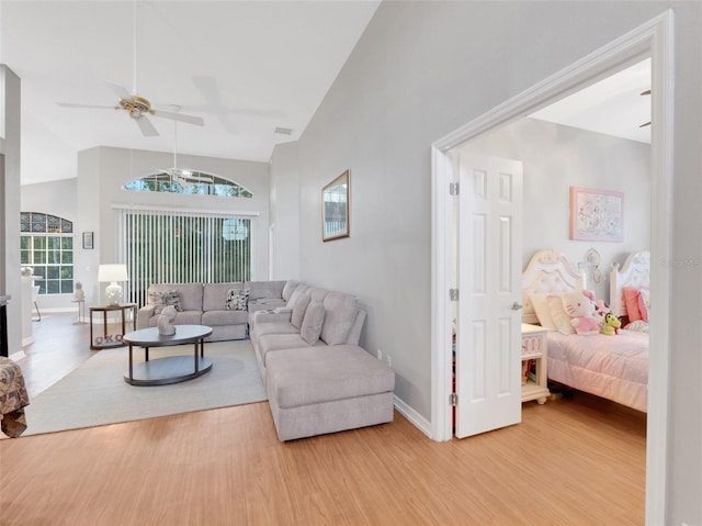 living room with hardwood / wood-style flooring, high vaulted ceiling, and ceiling fan