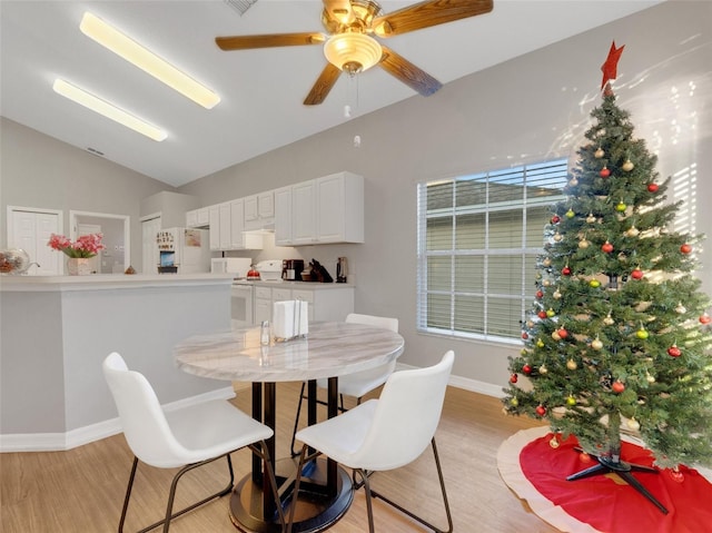 dining room featuring light hardwood / wood-style floors, ceiling fan, and lofted ceiling