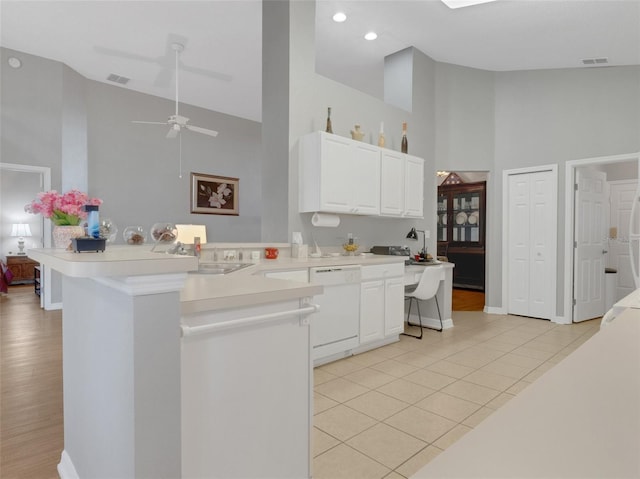 kitchen with dishwasher, kitchen peninsula, and high vaulted ceiling