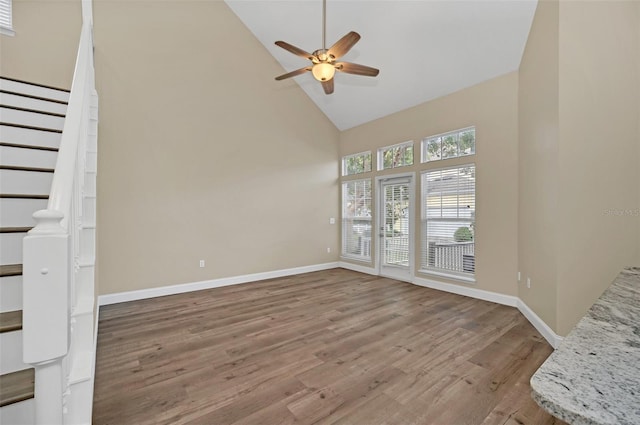 unfurnished living room with hardwood / wood-style flooring, ceiling fan, and high vaulted ceiling