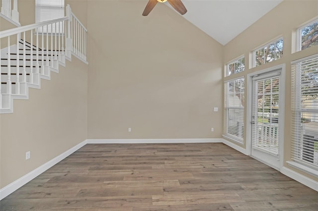 spare room with ceiling fan, plenty of natural light, high vaulted ceiling, and hardwood / wood-style flooring