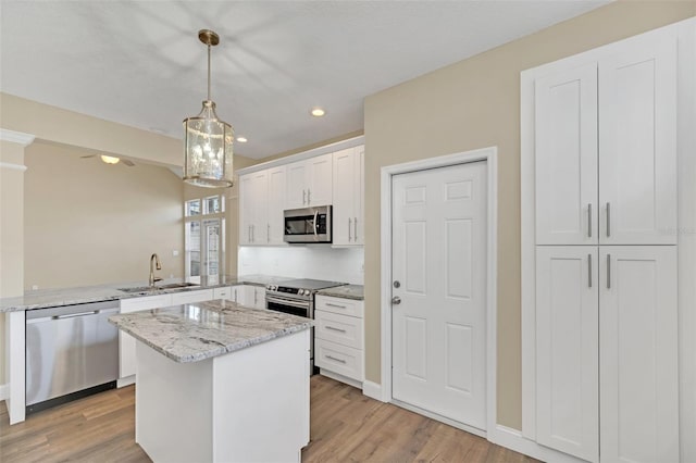 kitchen with sink, white cabinets, light hardwood / wood-style floors, and appliances with stainless steel finishes