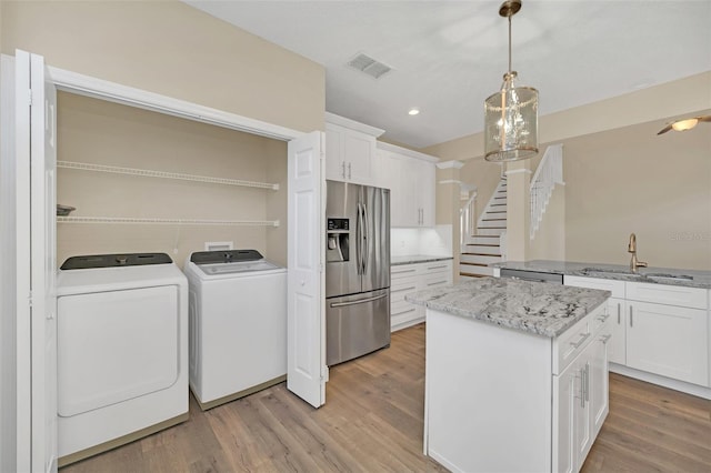 interior space featuring washer and clothes dryer, sink, and light hardwood / wood-style flooring