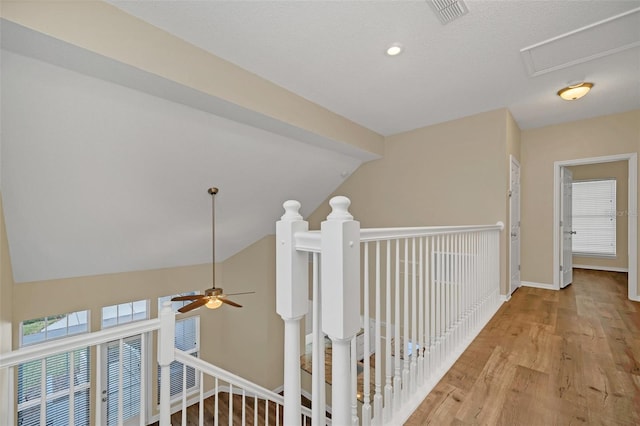 hallway with light hardwood / wood-style floors and lofted ceiling