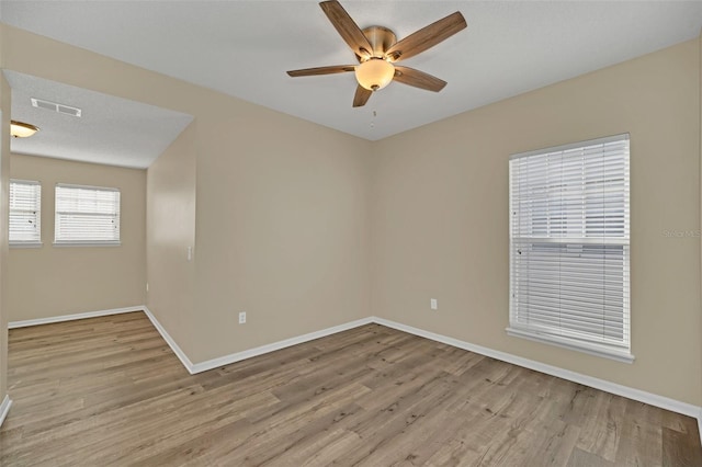 spare room with ceiling fan and light wood-type flooring