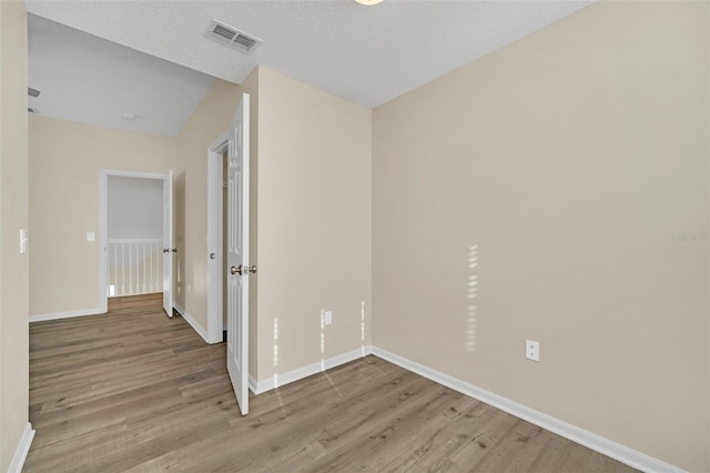 empty room featuring a textured ceiling and light wood-type flooring