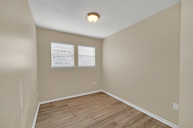 unfurnished room featuring a textured ceiling and light hardwood / wood-style flooring