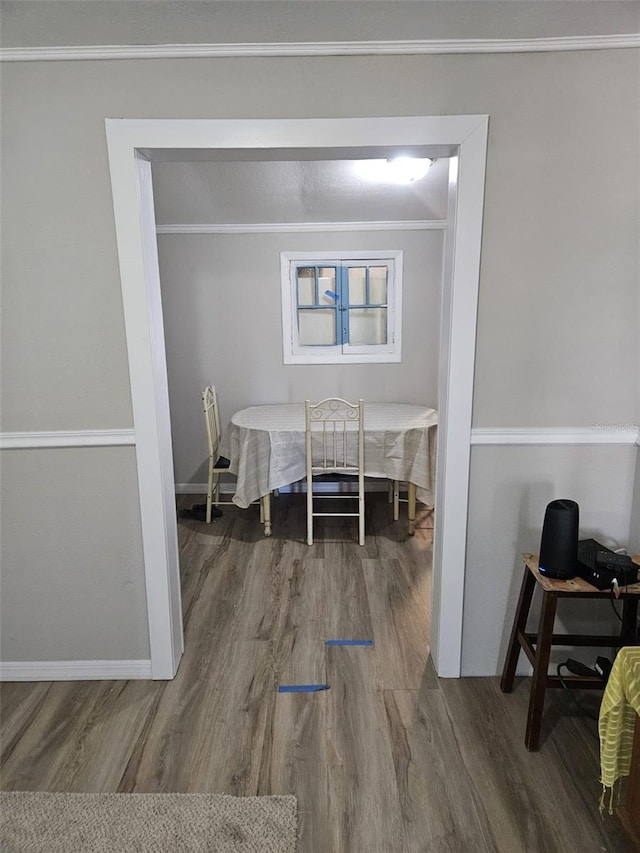 dining area with wood-type flooring and crown molding