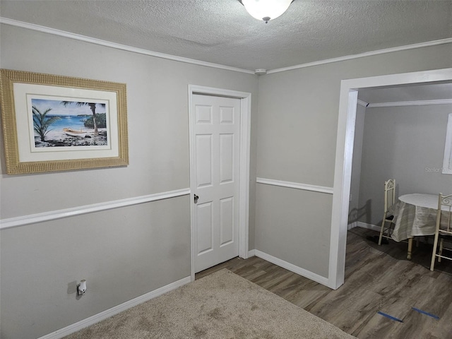 interior space featuring a textured ceiling, dark hardwood / wood-style floors, and crown molding