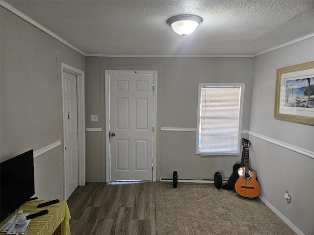 interior space with a textured ceiling, dark wood-type flooring, and ornamental molding