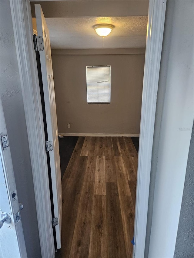 hall featuring dark hardwood / wood-style flooring and a textured ceiling