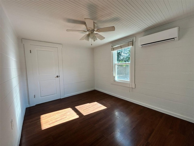 spare room with a wall mounted air conditioner, dark hardwood / wood-style flooring, and ceiling fan