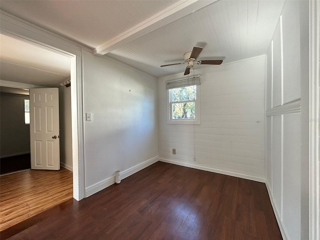 spare room featuring beam ceiling, ceiling fan, and dark wood-type flooring