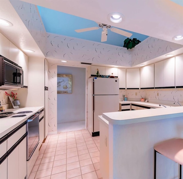 kitchen featuring white cabinets, ceiling fan, white appliances, and light tile patterned floors