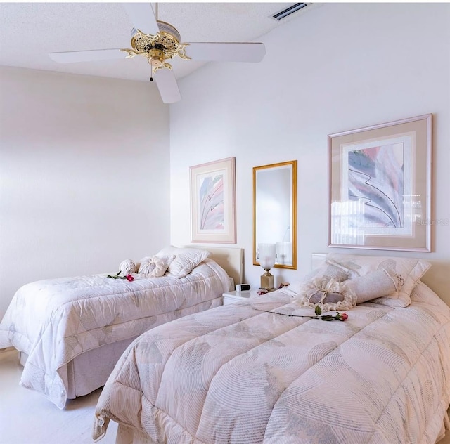 carpeted bedroom featuring ceiling fan and a textured ceiling