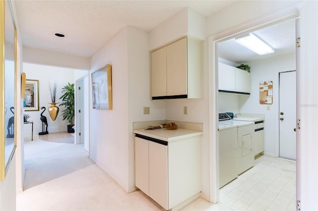 interior space with light carpet, a textured ceiling, and washing machine and dryer