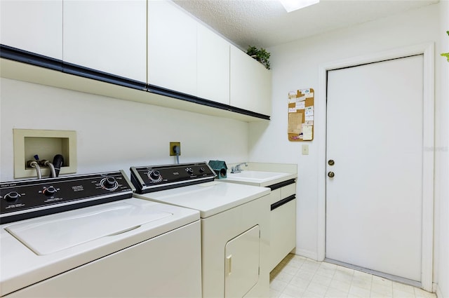 laundry room with washer and clothes dryer, sink, cabinets, and a textured ceiling