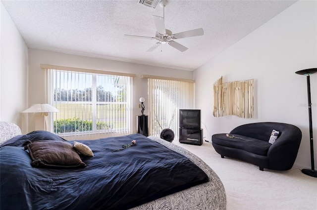 carpeted bedroom with a textured ceiling, ceiling fan, and lofted ceiling