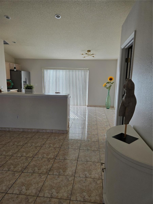 tiled spare room with a textured ceiling