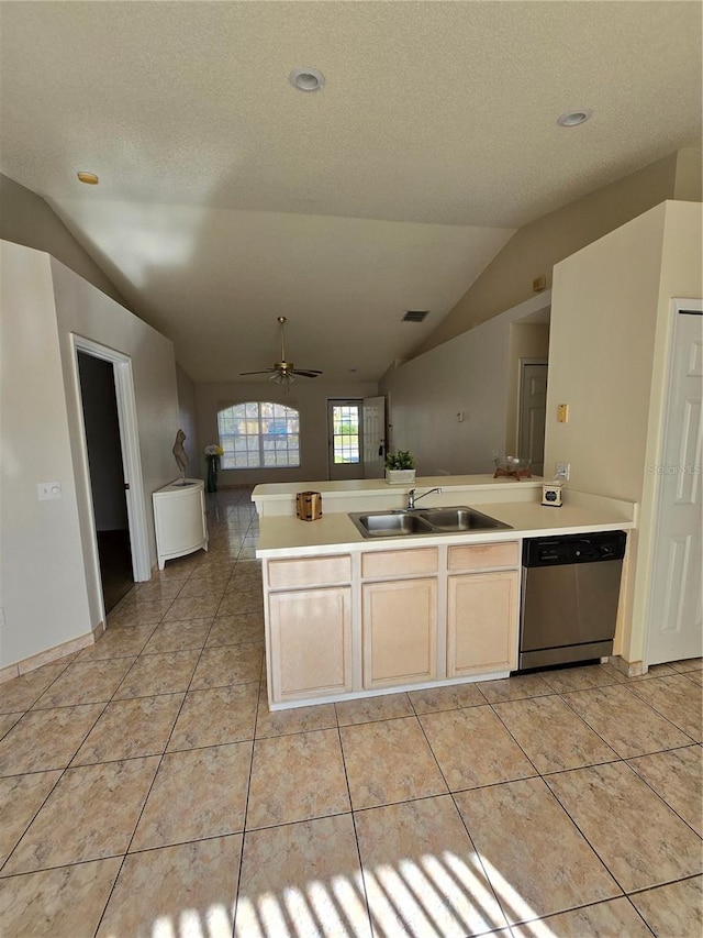 kitchen with sink, vaulted ceiling, stainless steel dishwasher, light tile patterned floors, and a textured ceiling