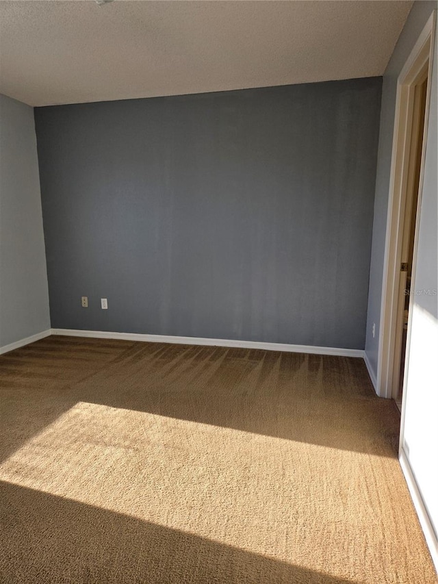 spare room featuring carpet flooring and a textured ceiling