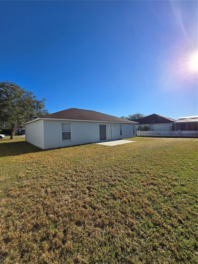 back of property with a yard and a patio area