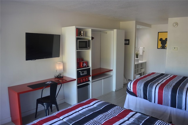 bedroom with hardwood / wood-style flooring and a textured ceiling