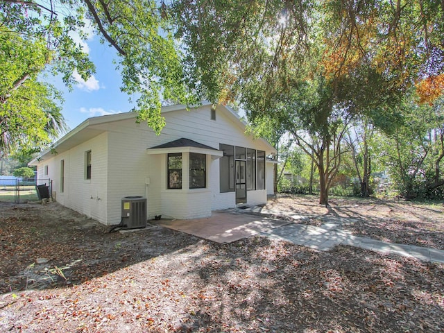 exterior space with a patio area, a sunroom, and central AC unit