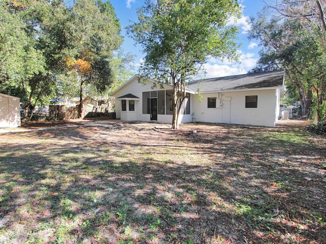 rear view of house with a sunroom and a lawn