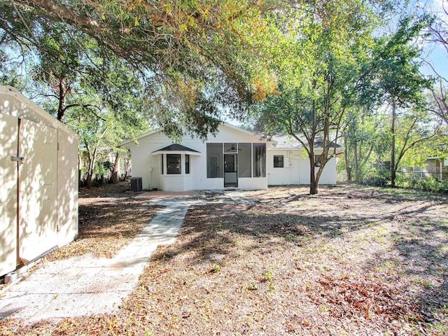 rear view of house with a sunroom and central AC unit