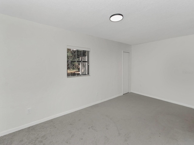 unfurnished room with a textured ceiling and carpet