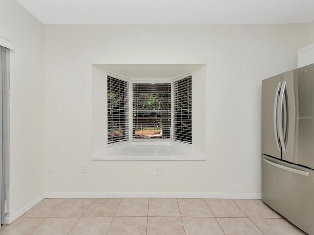 kitchen featuring stainless steel refrigerator and light tile patterned floors