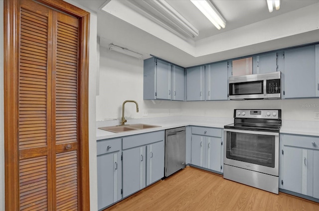 kitchen with light wood-type flooring, sink, and appliances with stainless steel finishes