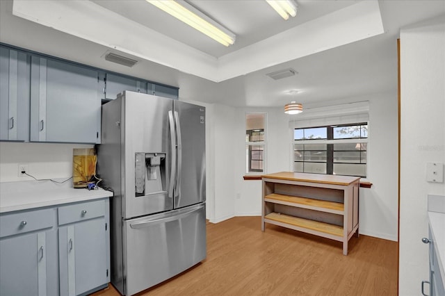 kitchen with light hardwood / wood-style floors and stainless steel refrigerator with ice dispenser