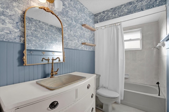 full bathroom with shower / tub combo with curtain, vanity, a textured ceiling, and toilet